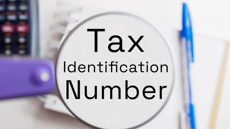 TIN certificate concept shown with magnifying glass highlighting Tax Identification Number and office supplies in the background